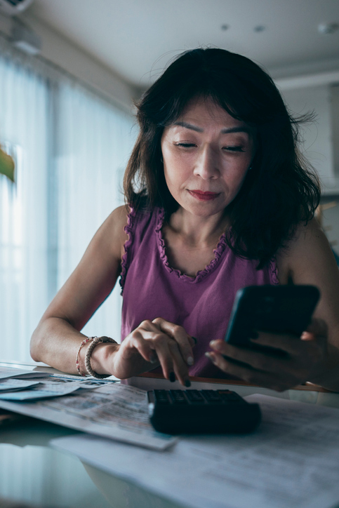 woman on phone while calculating